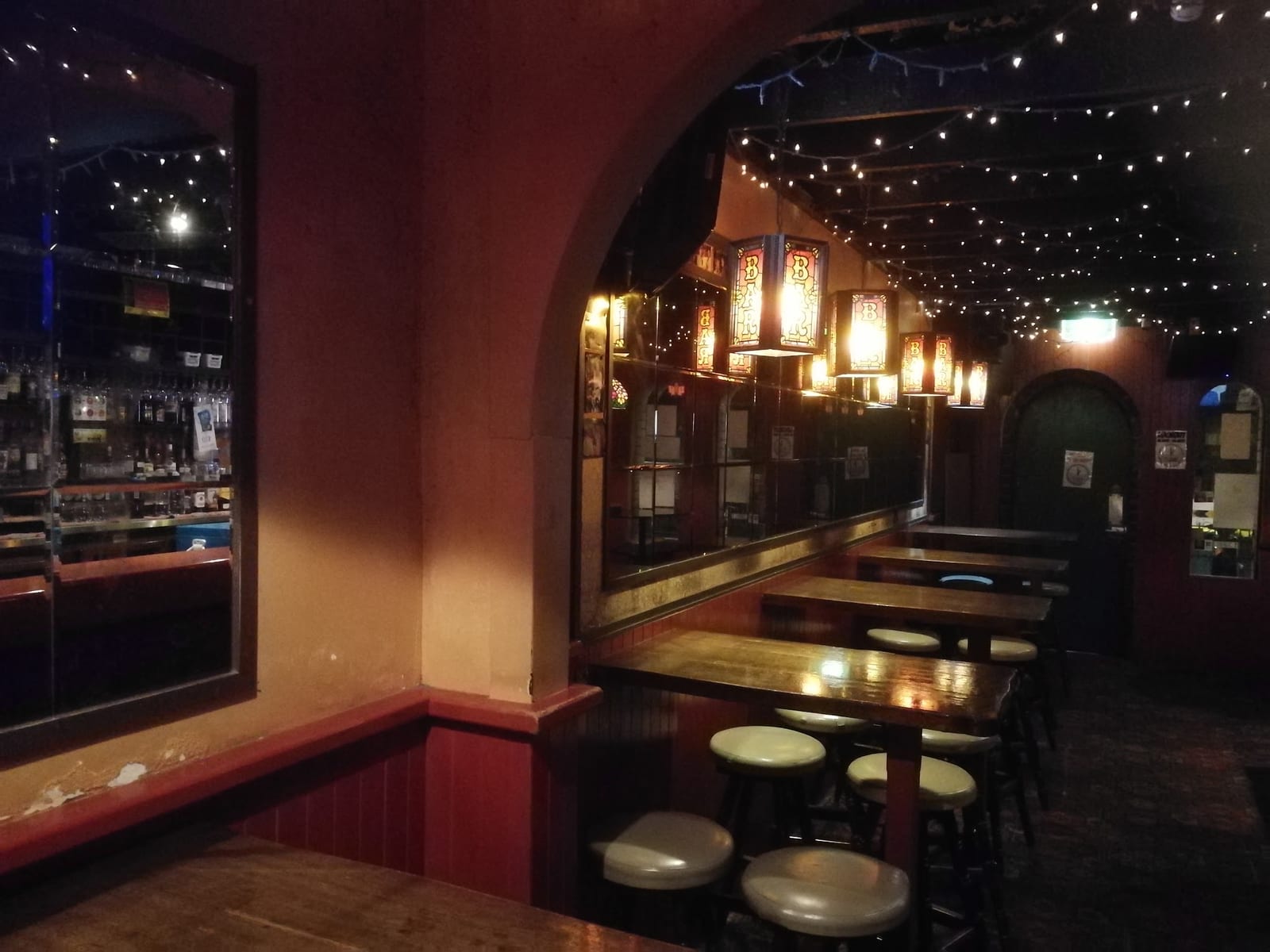 Interior of an old hotel bar with timber tables and stools before demolition